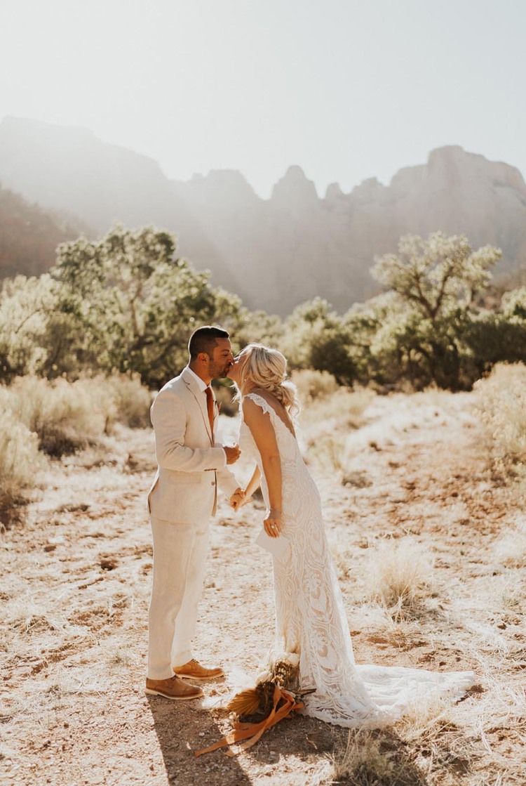Wdding couple kiss in front of beautiful scenery