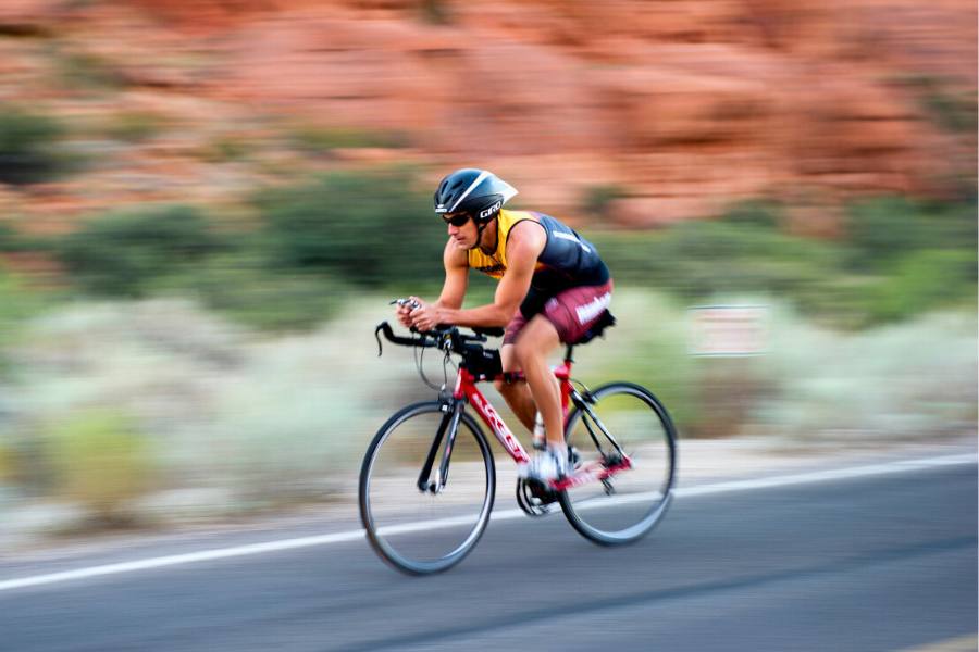 Cyclists riding through scenic desert roads in Southern Utah during the annual Spring Tour of St. George with red rock views and clear skies.
