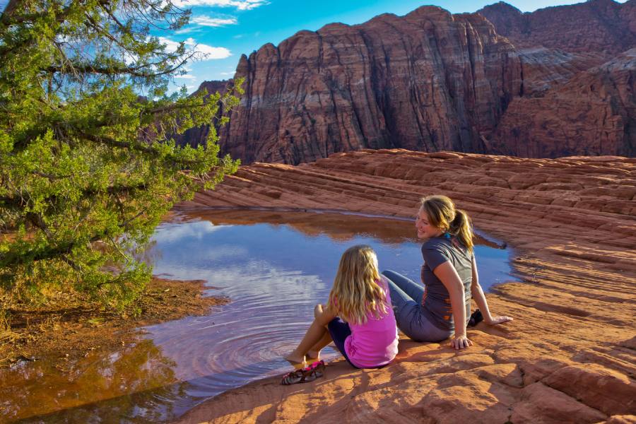 Family exploring red rock trails at Snow Canyon State Park just outside St. George on a sunny desert afternoon.