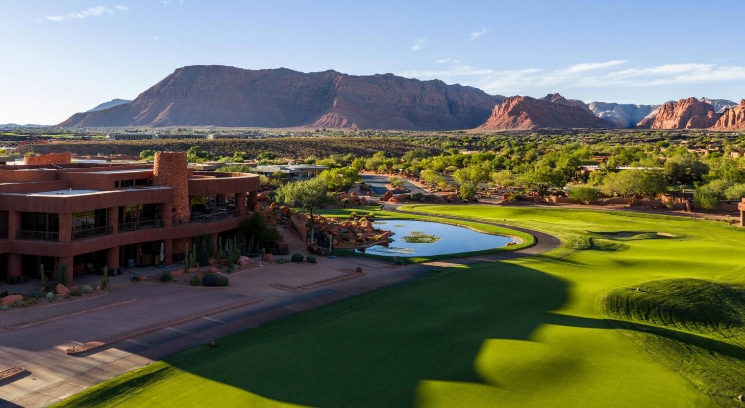Championship golf course in Southern Utah set against dramatic red rock cliffs and desert landscape.